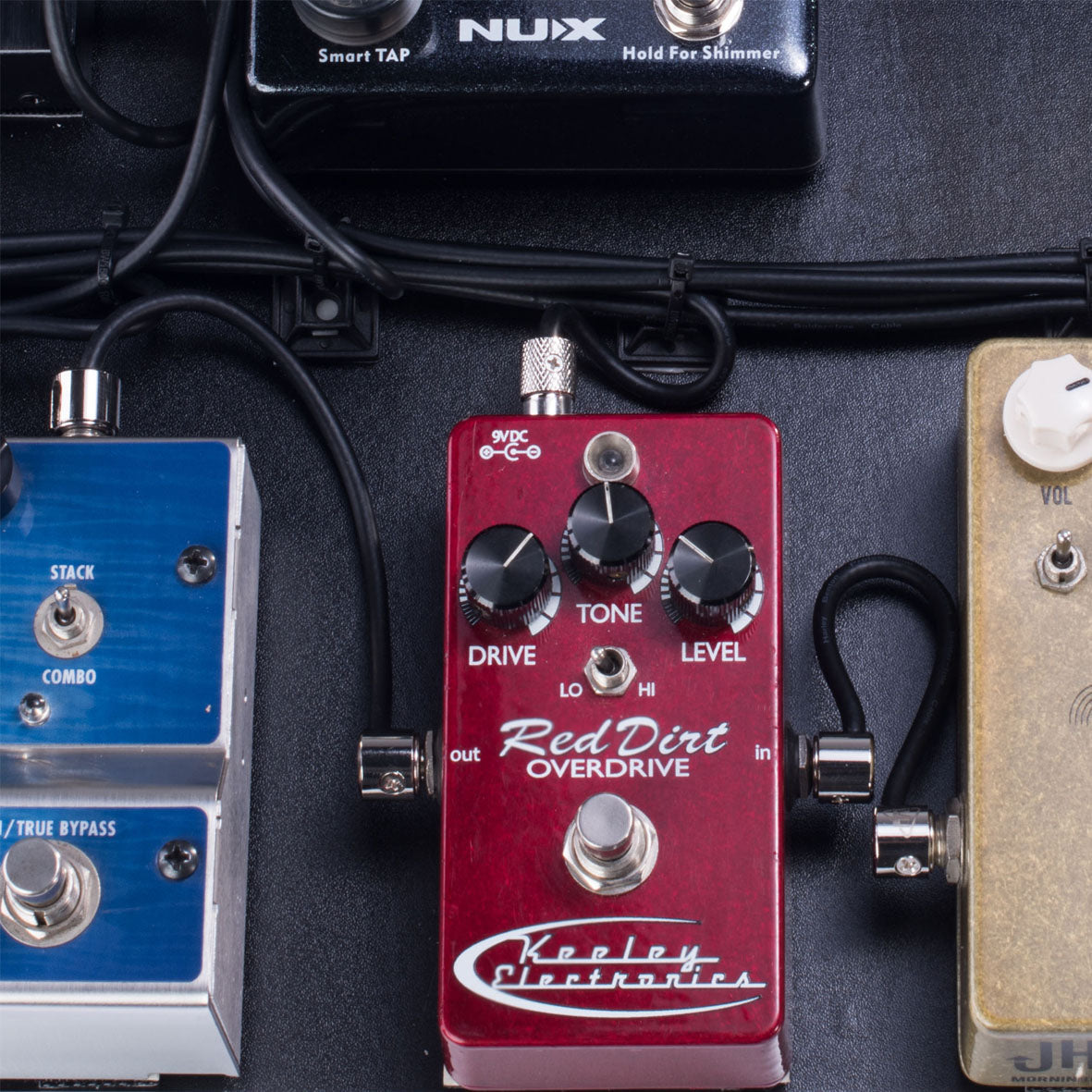 Custom right-angle patch cables connecting guitar pedals on a pedalboard