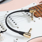 Gold-finish IVU FPC-415 patch cable shown on an electric guitar