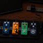 Five guitar effects pedals powered on a pedalboard with the SIPA-45W adapter